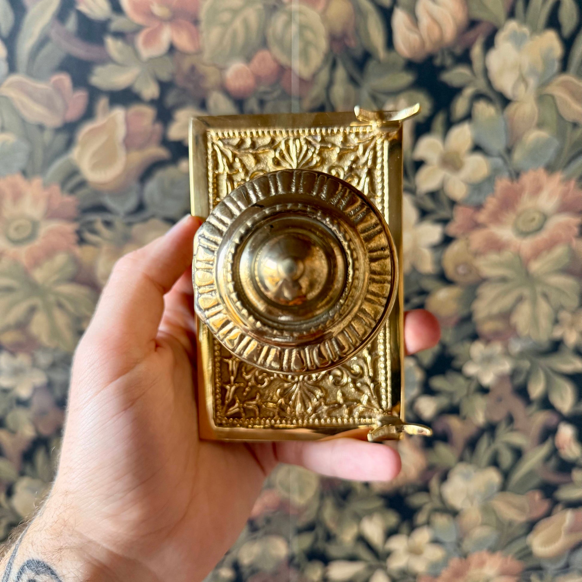 A detailed shot of the solid brass inkwell, showcasing its intricate antique-style engravings, hinged lid, and built-in pen holder.