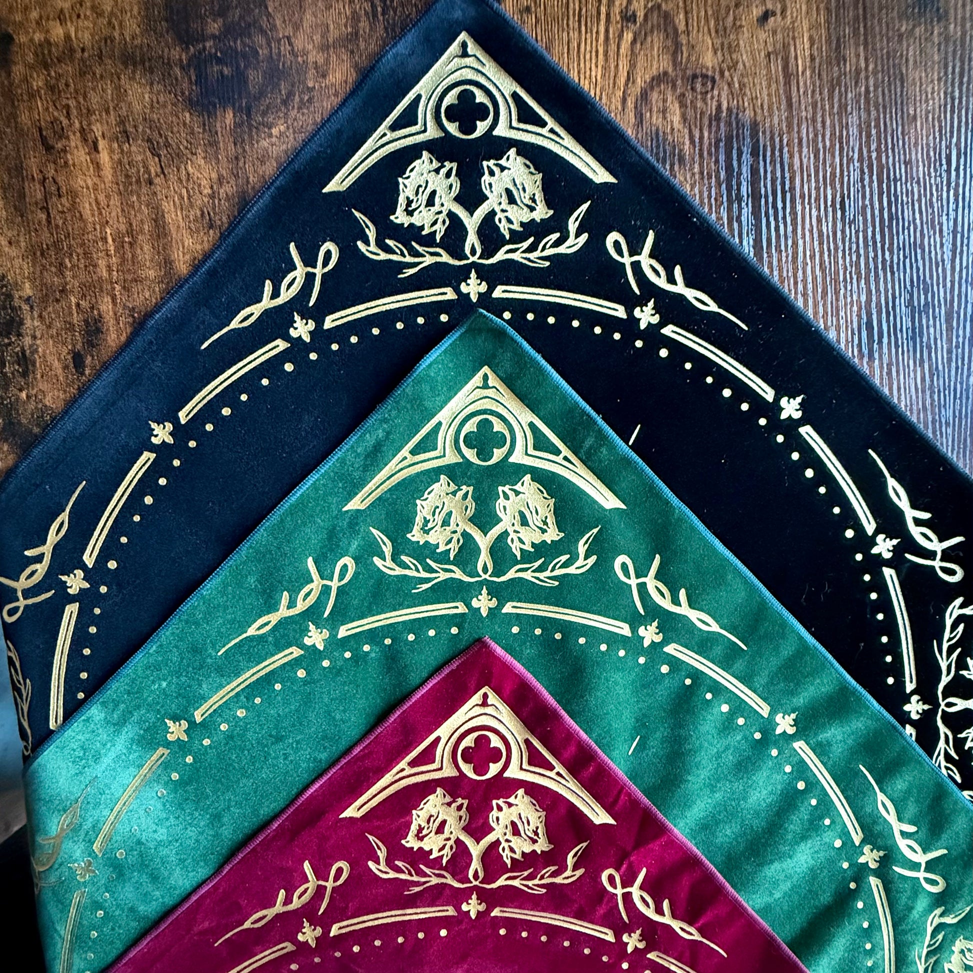The Eclipsa Altar Cloth collection displayed in Burgundy, Emerald, and Obsidian, showcasing their luxurious velvet texture and gold foil detailing.