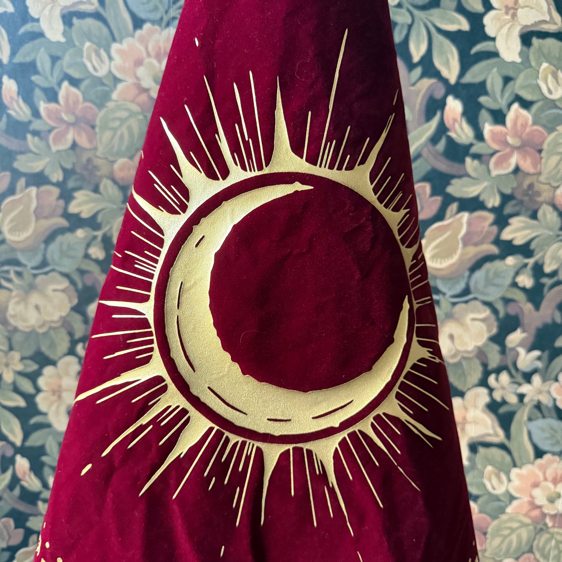 A detailed close-up of the gold foil emblem, intricately hand-stamped on the luxurious velvet fabric of the Eclipsa Altar Cloth.