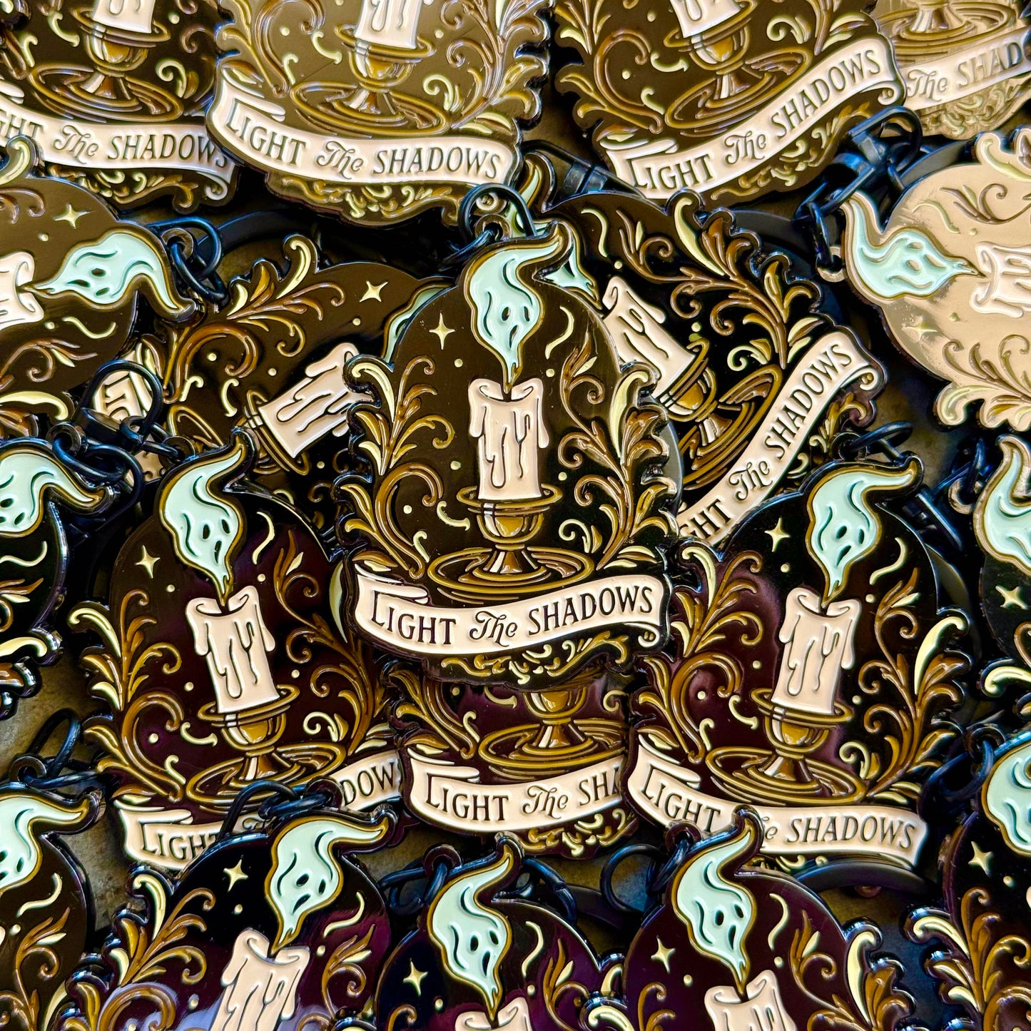 Keychains with candles and text 'Light the Shadows' on a dark background