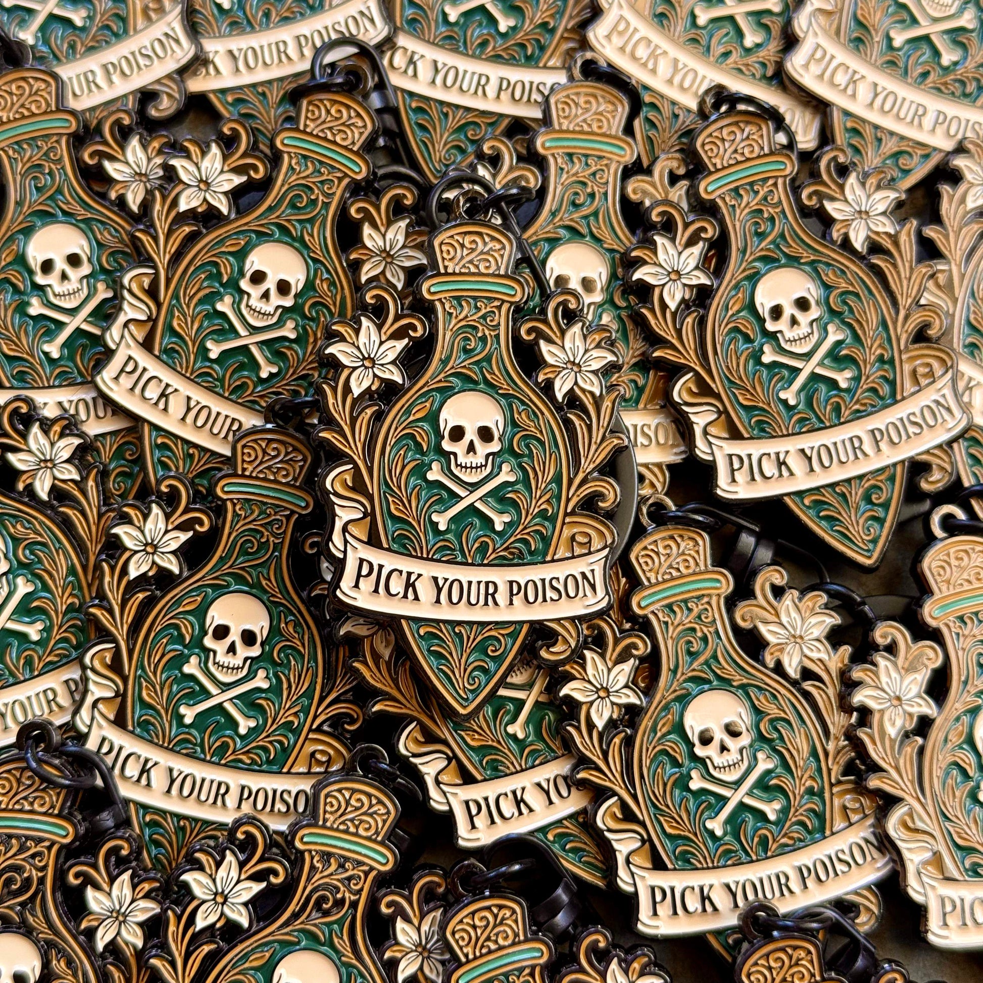 Decorative keychain with skull and crossbones design and 'Pick Your Poison' text.