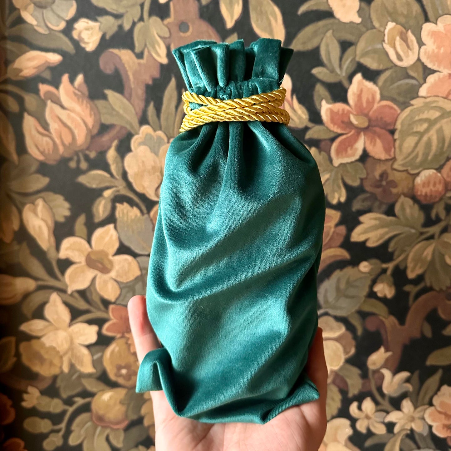 Elegant green velvet tarot bag with a gathered drawstring top, perfect for storing cards.