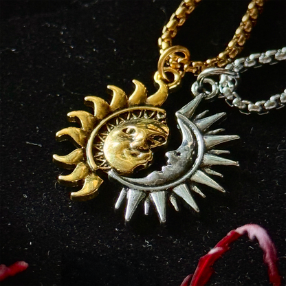 Necklace with sun and moon pendant on a dark background