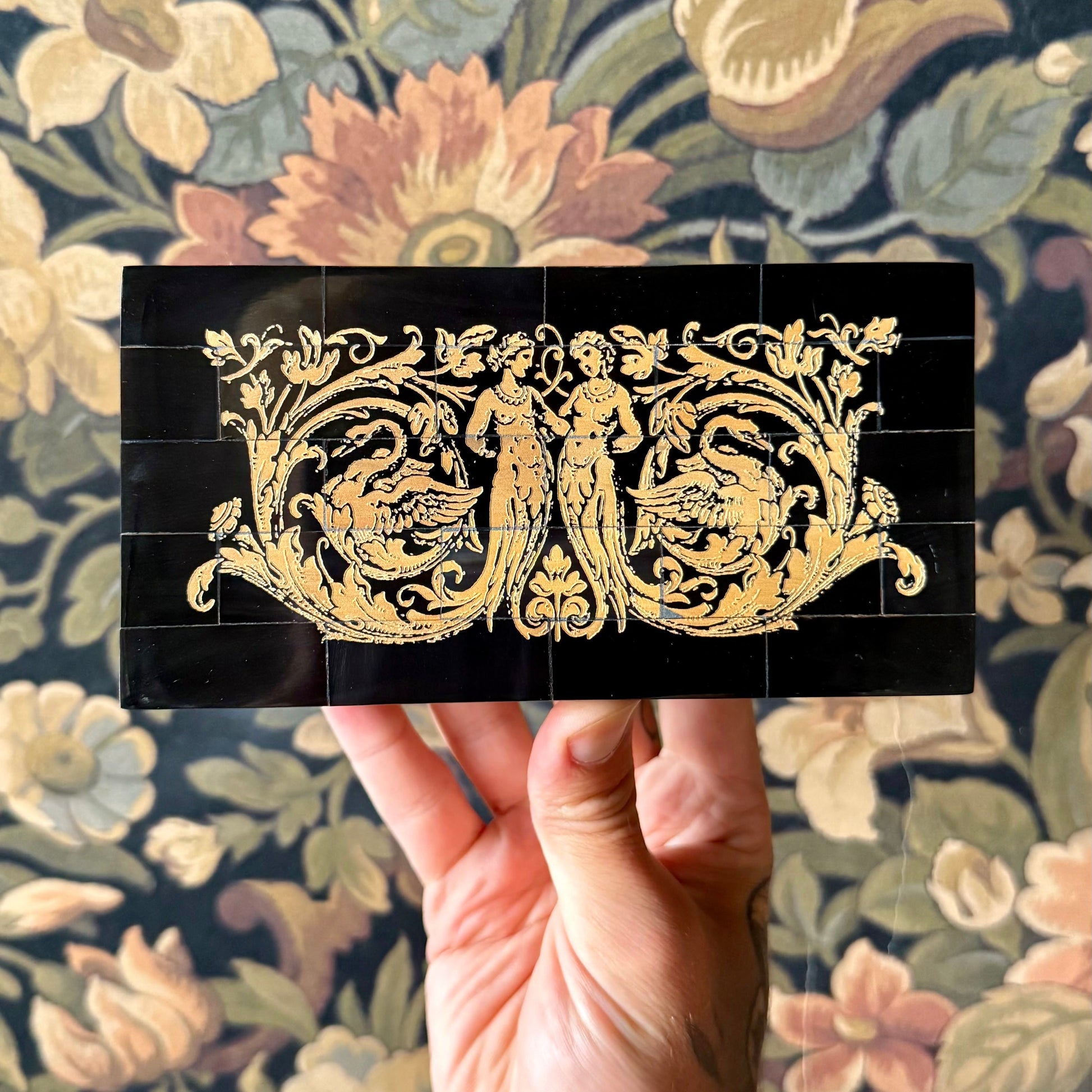 A rectangular black horn box with a mosaic tile exterior made from real water buffalo horn. The box features a brass latch and is displayed closed on a neutral background.