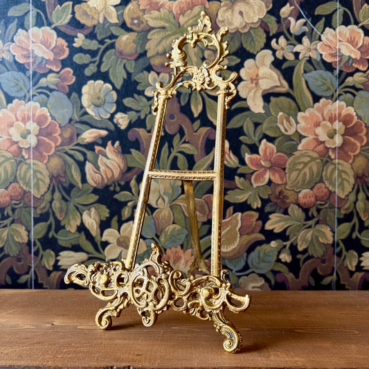 Ornate 16-inch brass easel with intricate Victorian scrollwork and floral detailing, standing upright on a white background.