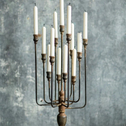 Decorative candle holder with multiple candles on a wooden surface and gray background