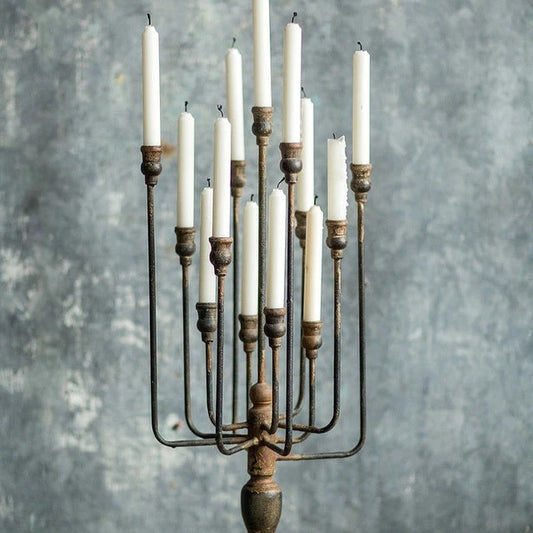 Decorative candle holder with multiple candles on a wooden surface and gray background