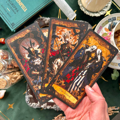 A fan spread of three tarot cards displayed together, each with intricate illustrations from the Wonderland Shadows Tarot Deck, showcasing the deck’s cohesive design and enchanting themes.