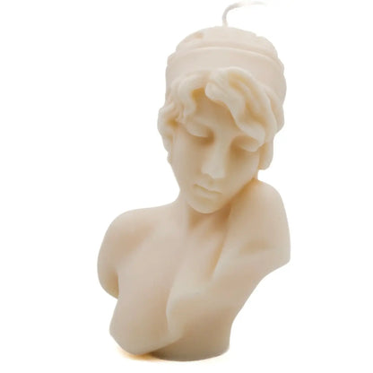 An off-white wax candle sculpted in the shape of a classical female bust with a wavy hairpiece, shown against a plain white background.