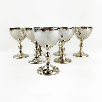 A set of six polished silver goblets arranged in a semi-circle on a plain white background.