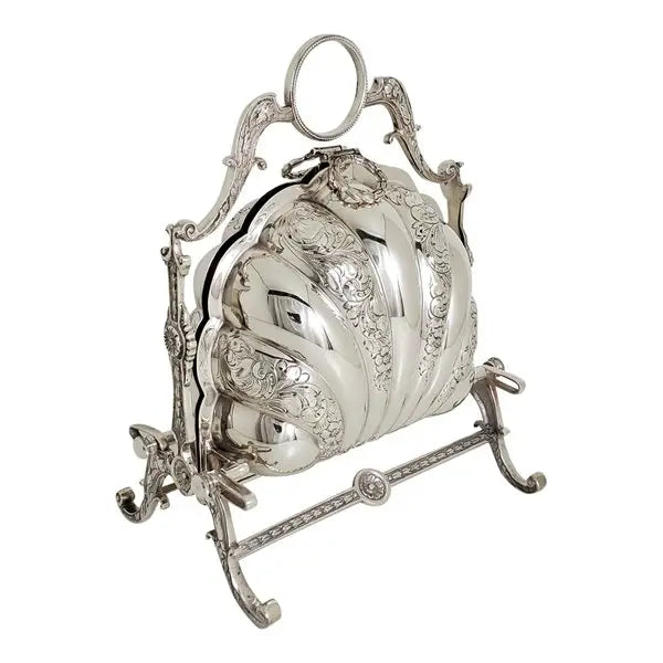 An ornate silver-toned decorative object with a ribbed, carved surface and an openwork metal stand, photographed on a plain white background.