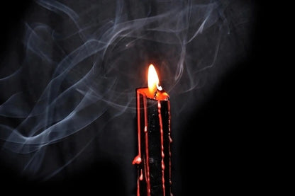 Candle with smoke against a dark background